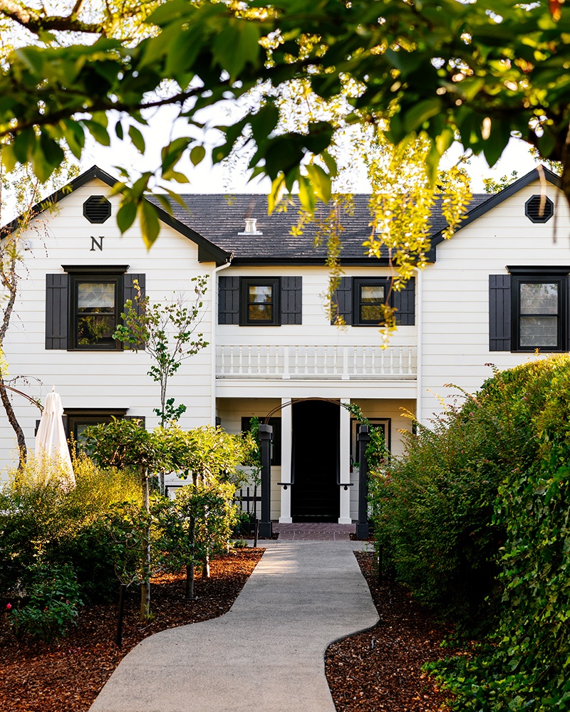 Verdant pathways and farmhouse architecture at MacArthur Place in Sonoma